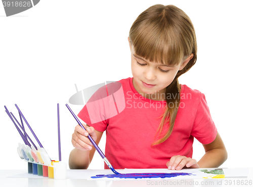 Image of Little girl is painting with gouache