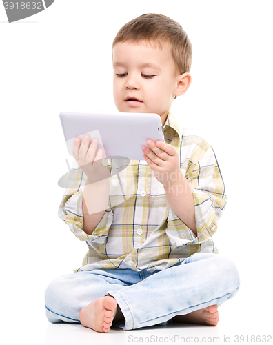 Image of Young boy is using tablet