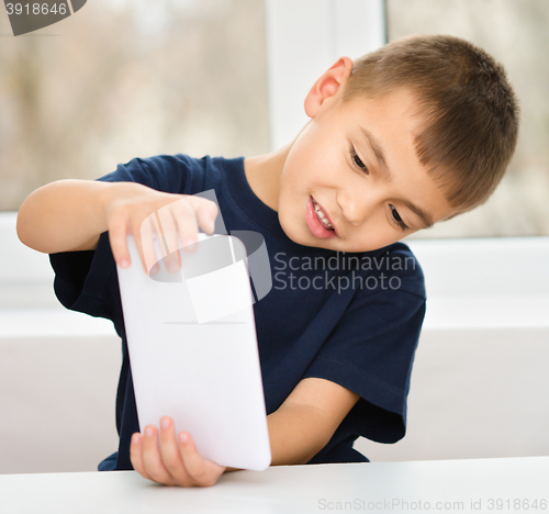 Image of Young boy is using tablet