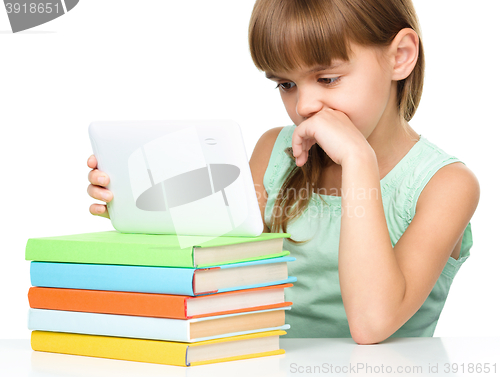 Image of Young girl is using tablet while studying
