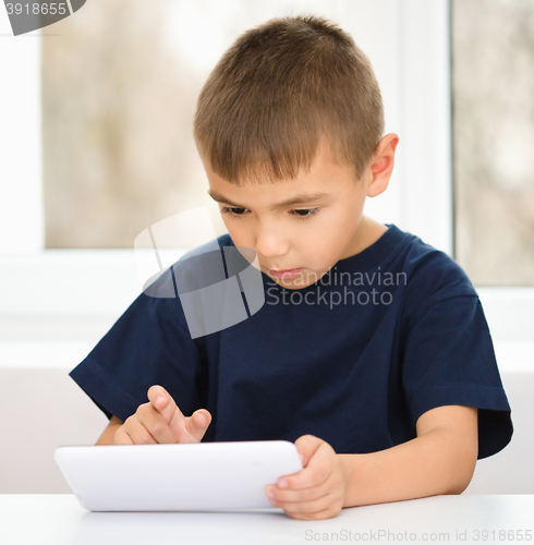 Image of Young boy is using tablet