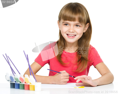 Image of Little girl is painting with gouache