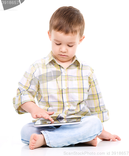 Image of Young boy is using tablet
