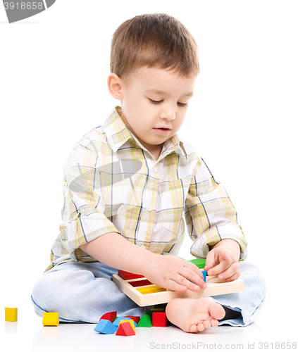 Image of Little boy is playing with toys