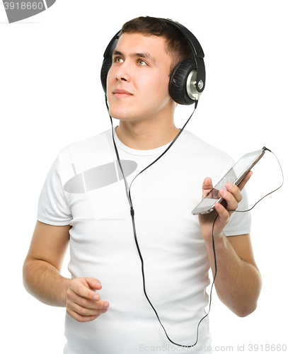 Image of Young man enjoying music using headphones