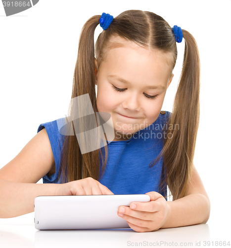 Image of Young cheerful girl is using tablet
