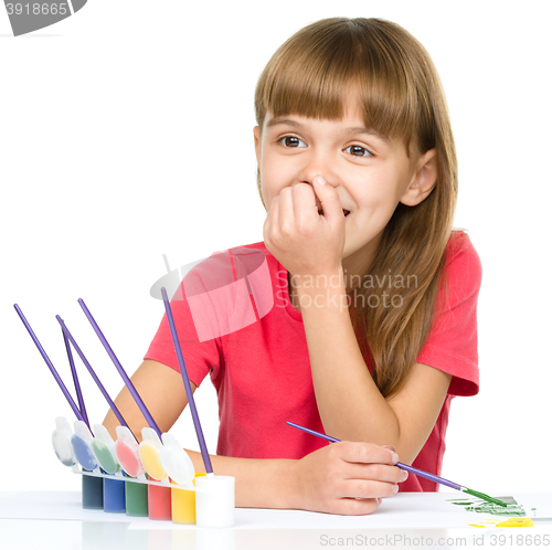 Image of Little girl is painting with gouache