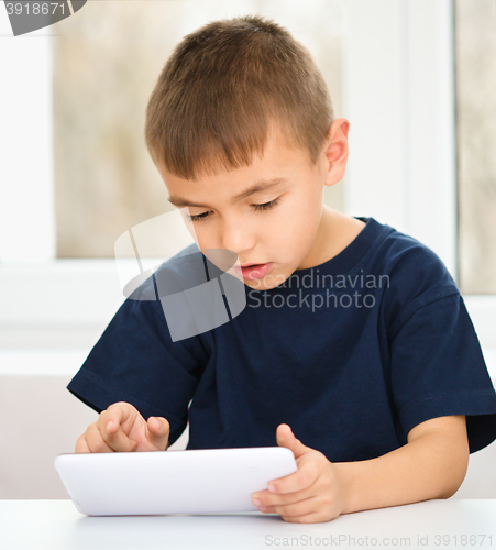 Image of Young boy is using tablet