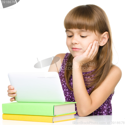 Image of Young girl is using tablet while studying