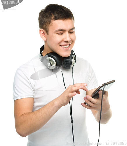 Image of Young man enjoying music using headphones