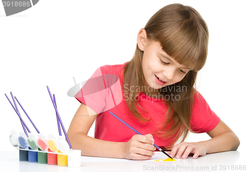 Image of Little girl is painting with gouache