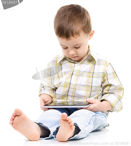 Image of Young boy is using tablet