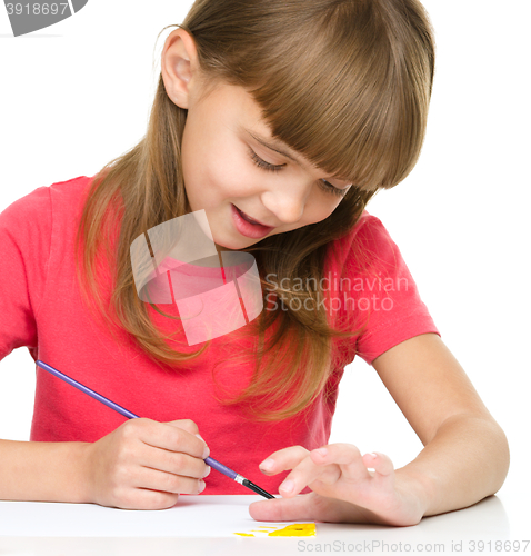 Image of Little girl is painting with gouache