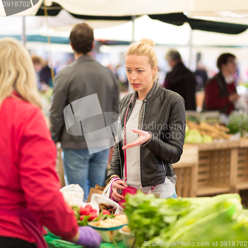 Image of Woman buying vegetable at local food market. 