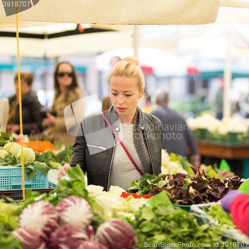 Image of Woman buying vegetable at local food market. 