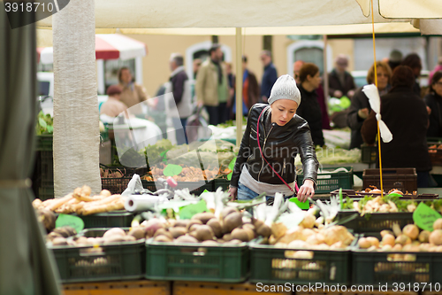 Image of Woman buying vegetable at local food market. 