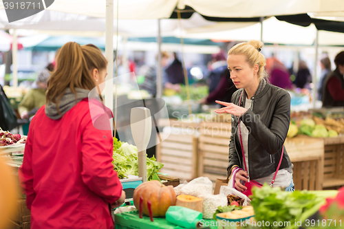 Image of Woman buying vegetable at local food market. 