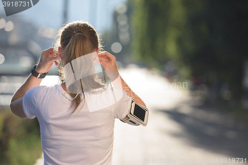 Image of jogging woman setting phone before jogging