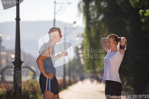 Image of jogging couple planning running route  and setting music