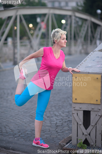 Image of blonde woman  stretching before morning jogging
