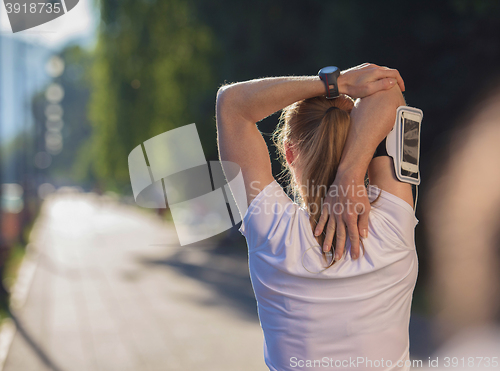 Image of blonde woman  stretching before morning jogging