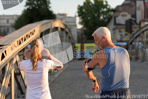 Image of jogging couple planning running route  and setting music