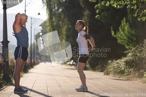 Image of couple warming up and stretching before jogging