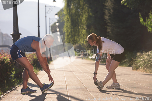 Image of couple warming up and stretching before jogging