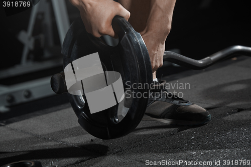 Image of Man preparing barbell at gym