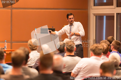 Image of Business speaker giving a talk in conference hall.