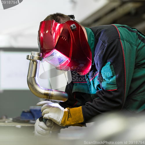 Image of Industrial worker welding in metal factory.