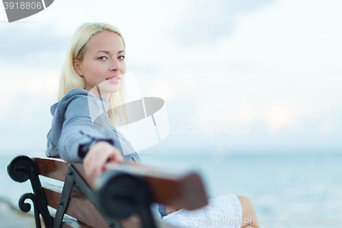 Image of Lady sitting on a bench outdoors