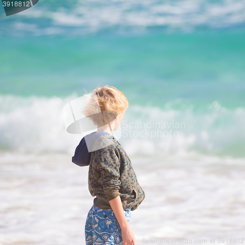 Image of Boy playing with toys on beach.