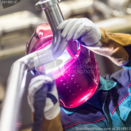 Image of Industrial worker welding in metal factory.