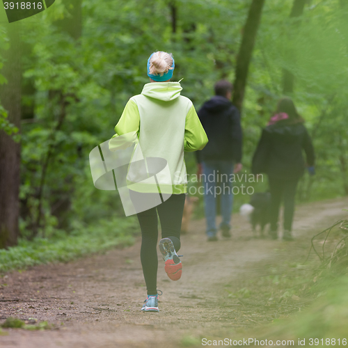 Image of Sporty young female runner in the forest. 