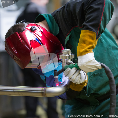 Image of Industrial worker welding in metal factory.