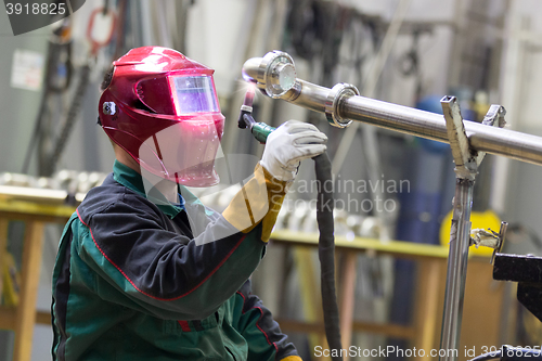 Image of Industrial worker welding in metal factory.