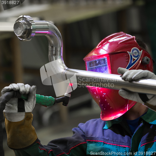 Image of Industrial worker welding in metal factory.