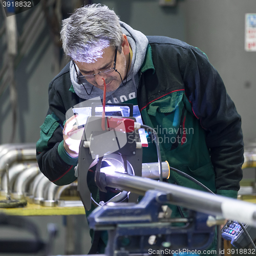 Image of Industrial worker setting orbital welding machine.