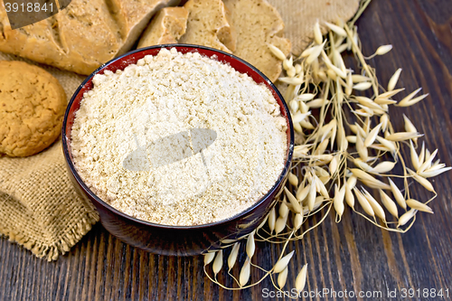 Image of Flour oat in bowl with bread on sackcloth and board