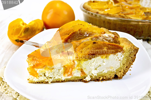 Image of Pie with curd and persimmons in plate on napkin silicone and boa
