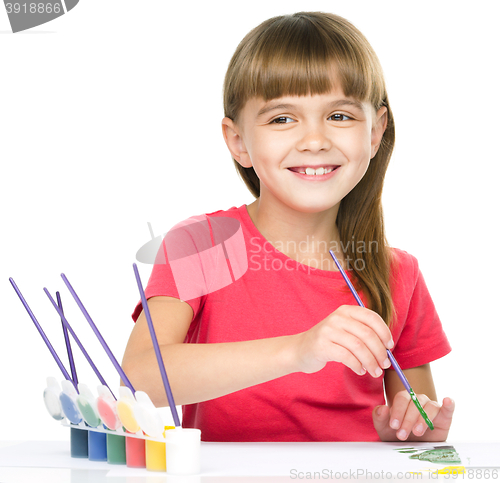 Image of Little girl is painting with gouache