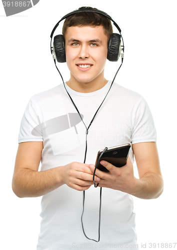 Image of Young man enjoying music using headphones