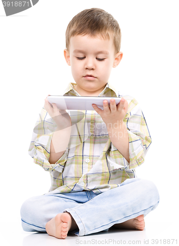 Image of Young boy is using tablet