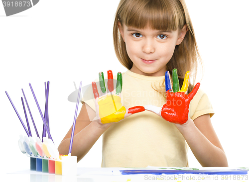 Image of Portrait of a cute girl playing with paints
