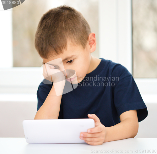 Image of Young boy is using tablet