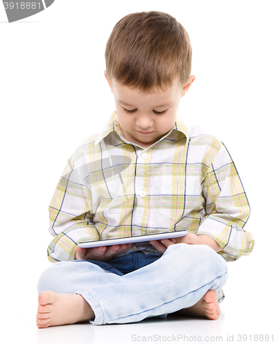 Image of Young boy is using tablet
