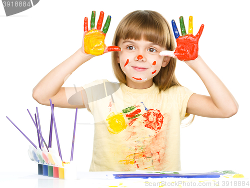 Image of Portrait of a cute girl playing with paints