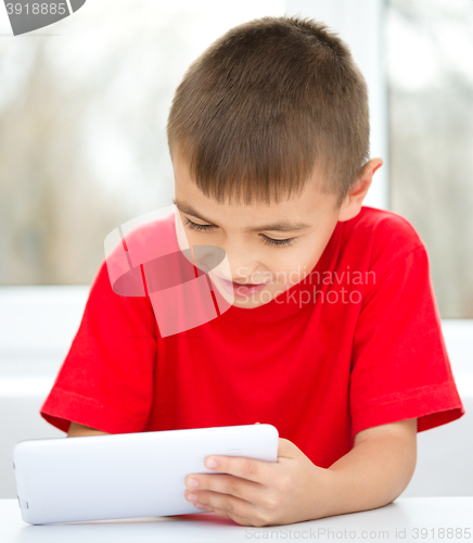 Image of Young boy is using tablet