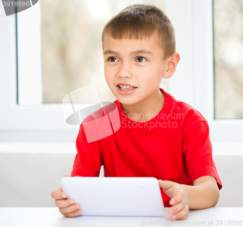 Image of Young boy is using tablet